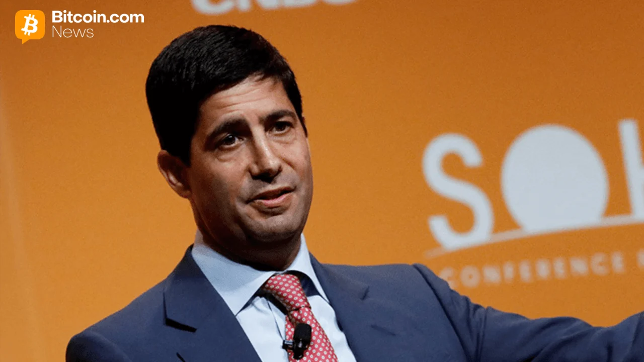 Close-up headshot portrait photo of financial executive Kevin Warsh speaking against an orange backdrop.