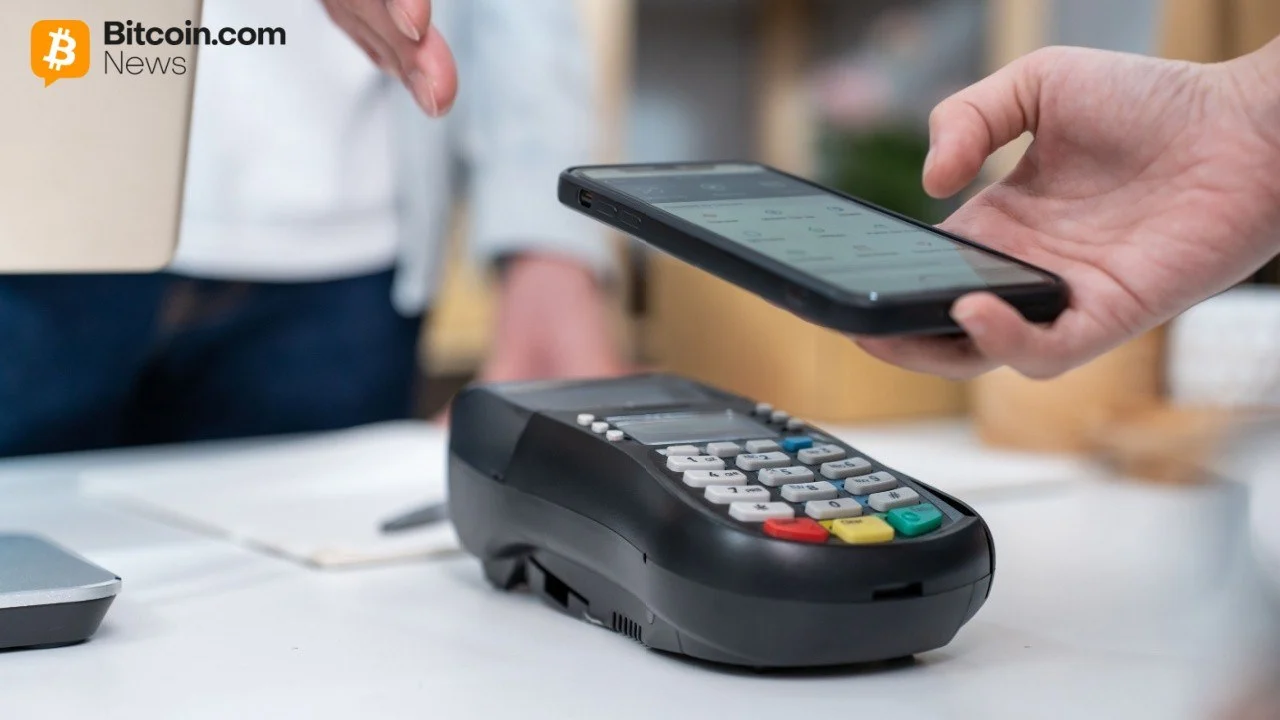 Close-up view of a retail consumer holding a smartphone above a sleek black modern point-of-sale payment terminal.