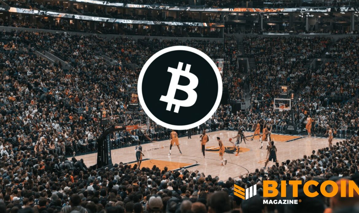 Bitcoin logo displayed in a crowded arena during an event